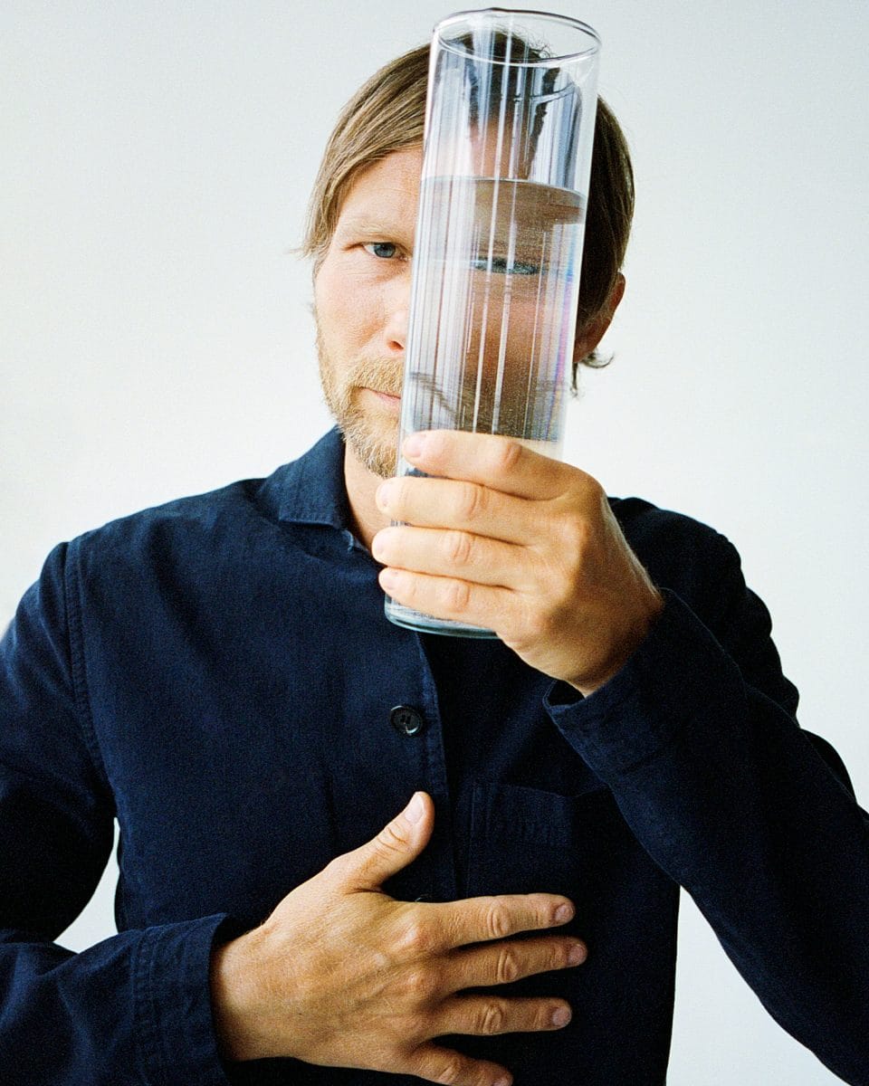 Chef and part-owner of restaurant Geranium in Copenhagen, Rasmus Kofoed, looking through a glass of water.